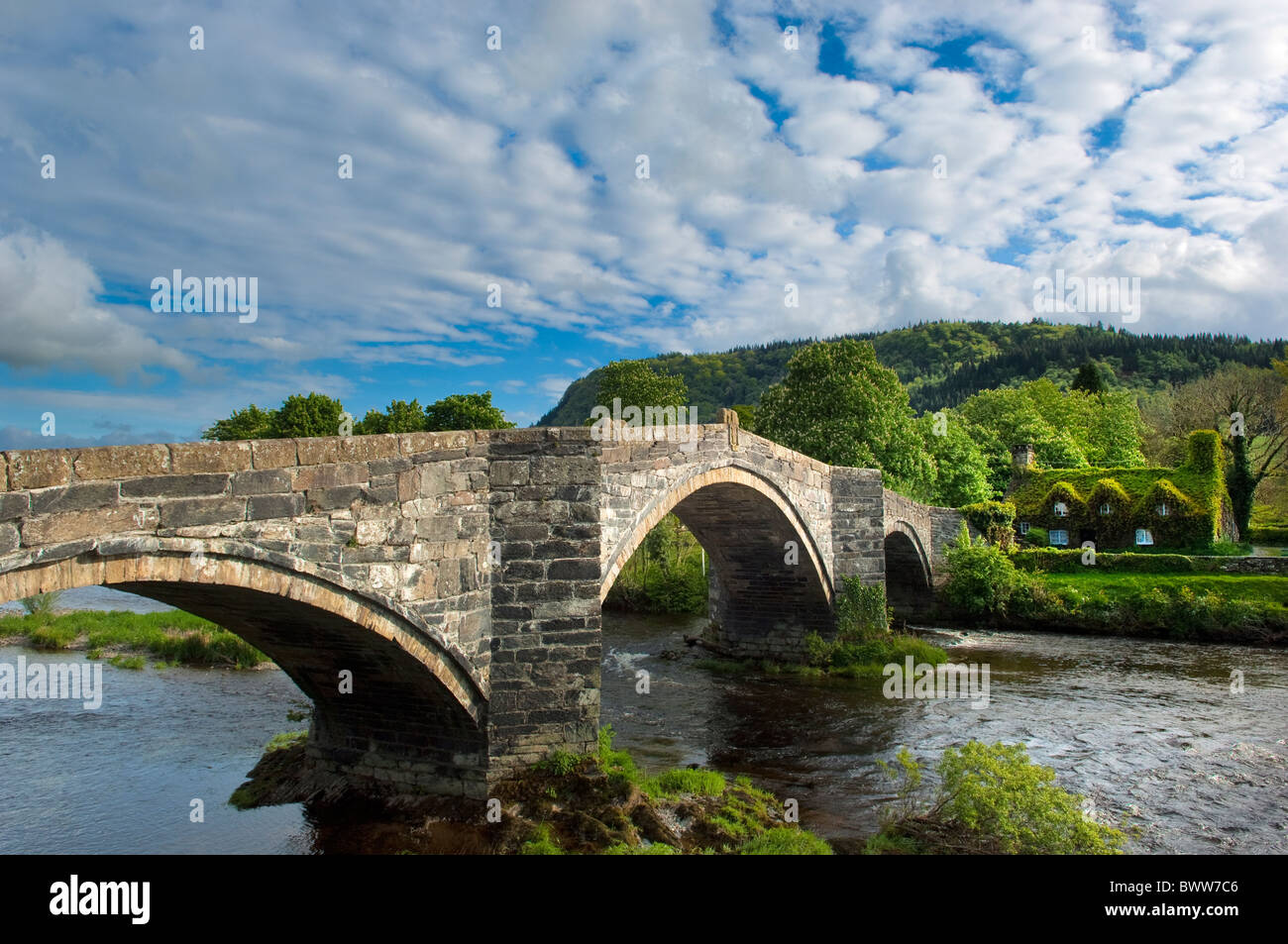 The Pont Fawr bridge over the River Conwy in Llanrwst. Tu Hwnt i'r Bont courthouse, now tea-rooms, visible Stock Photo