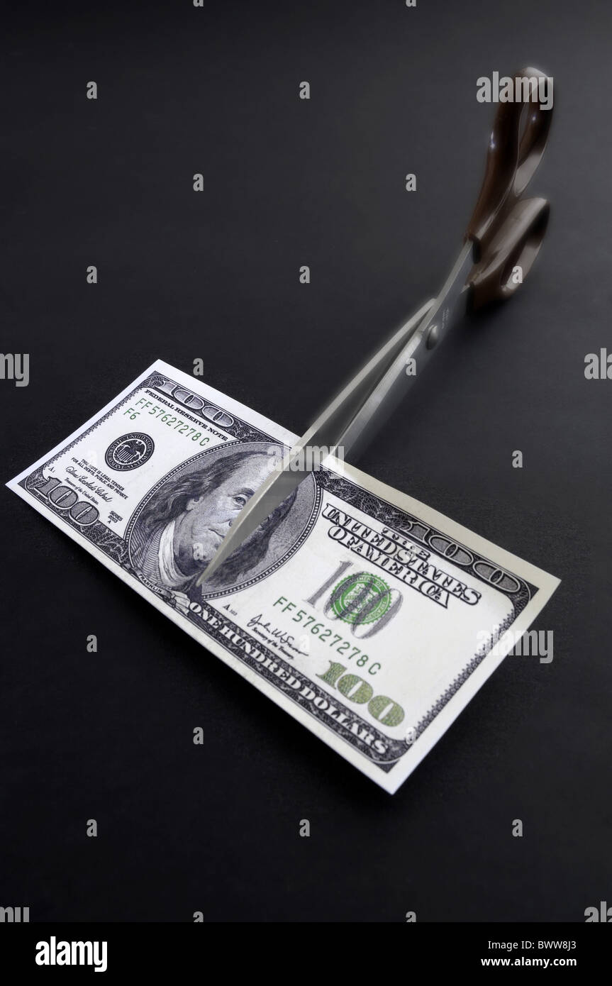 Money note bill 100 one hundred Dollar scissors halve cut cash destroy broken depreciation inflation fina Stock Photo