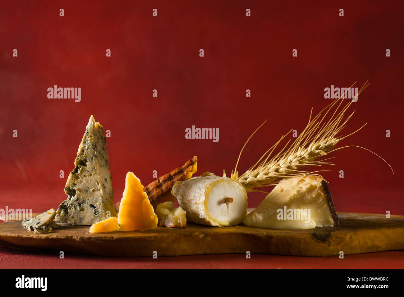 A wood cuttingboard with, from left to right: Cabrales (Cow - Spain), Roomano (Cow - Holland), Majorero Pimenton (Goat - Canary Stock Photo