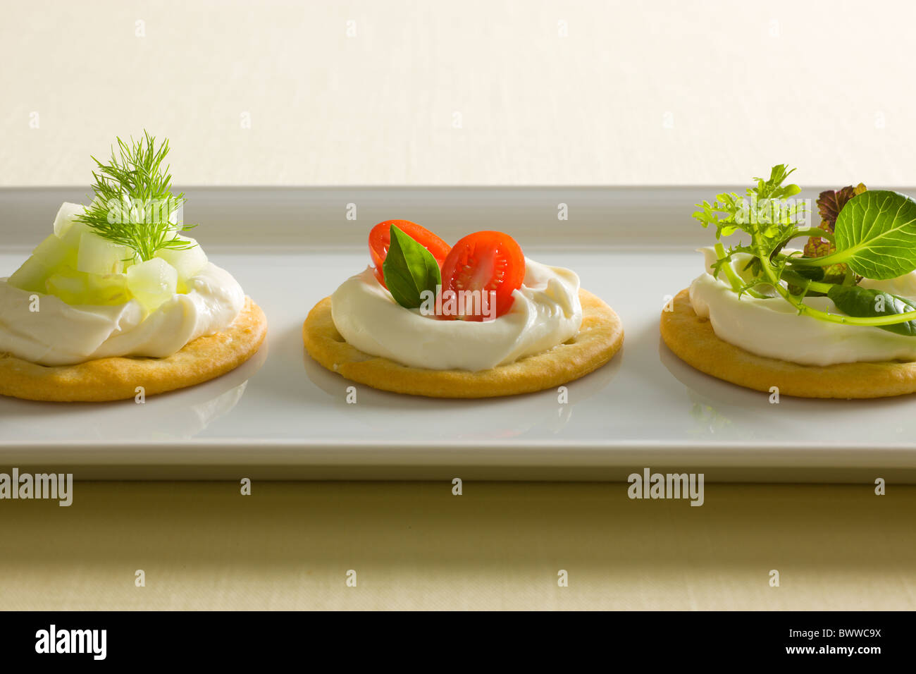 Crackers with Creamy Cheese spread, garnished with Tomatoes, Basil