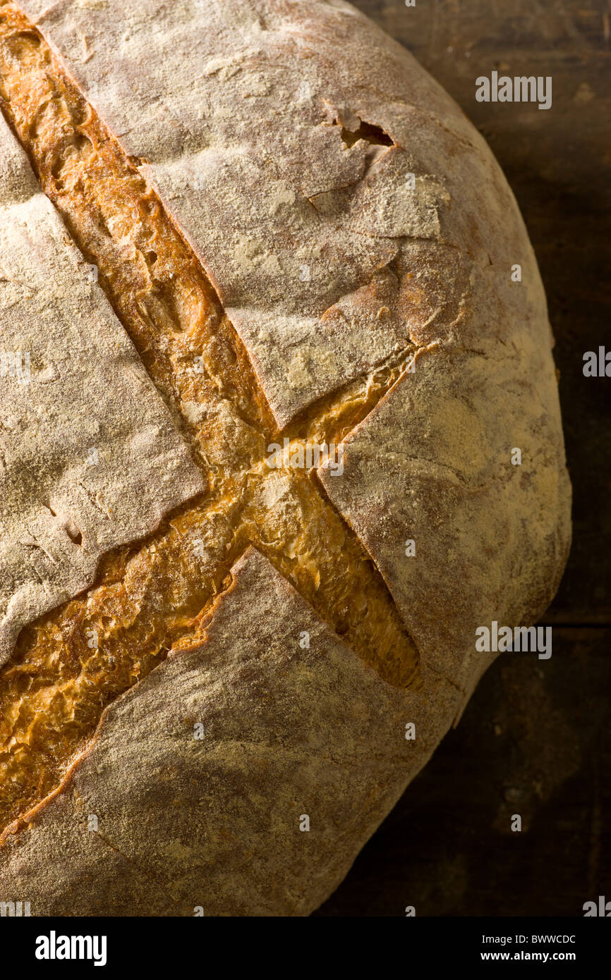 A loaf of artisanal bread on a rustic wood surface. Stock Photo