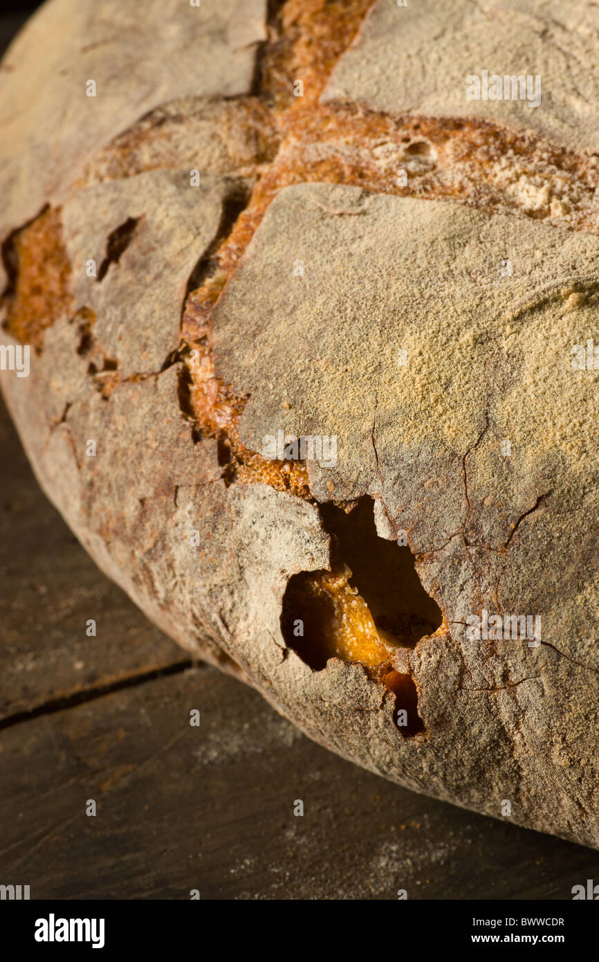 A loaf of artisanal bread on a rustic wood surface. Stock Photo