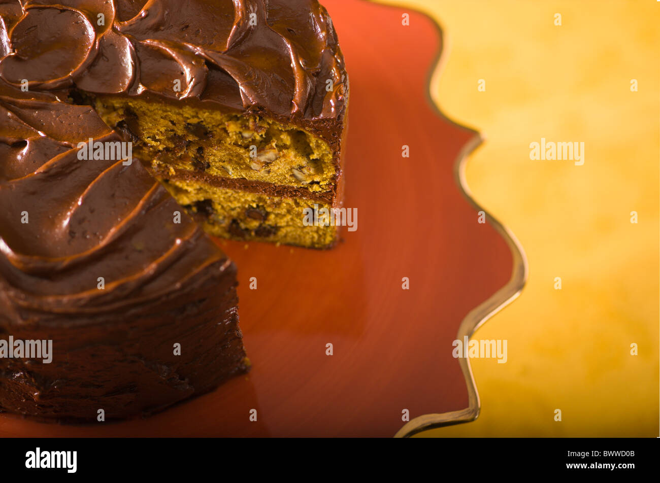 Pumpkin cake with chocolate chips and pecans, layered and covered with chocolate frosting Stock Photo