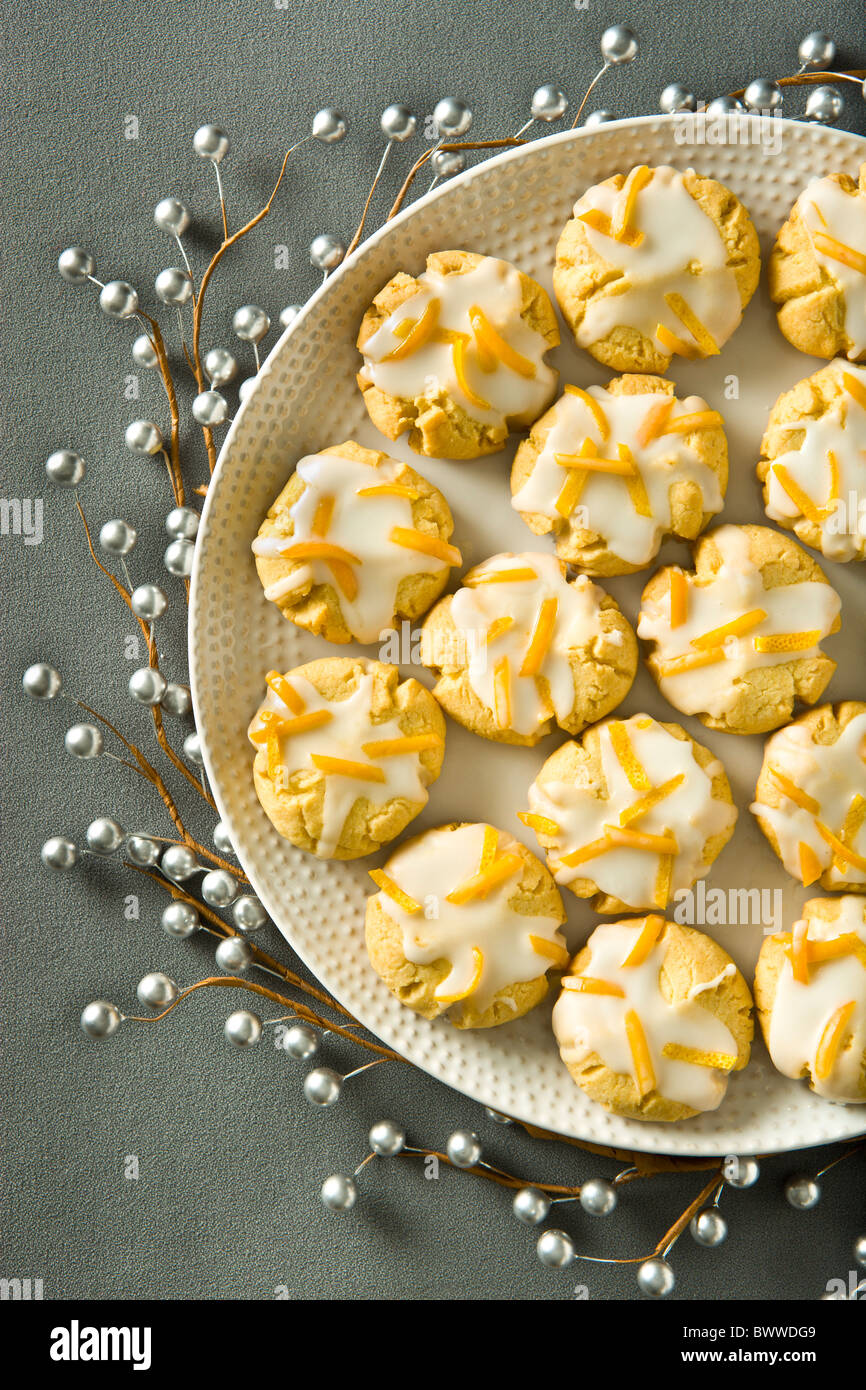 Orange Butter Cookies finished with orange zest icing on a grey holiday background. Stock Photo