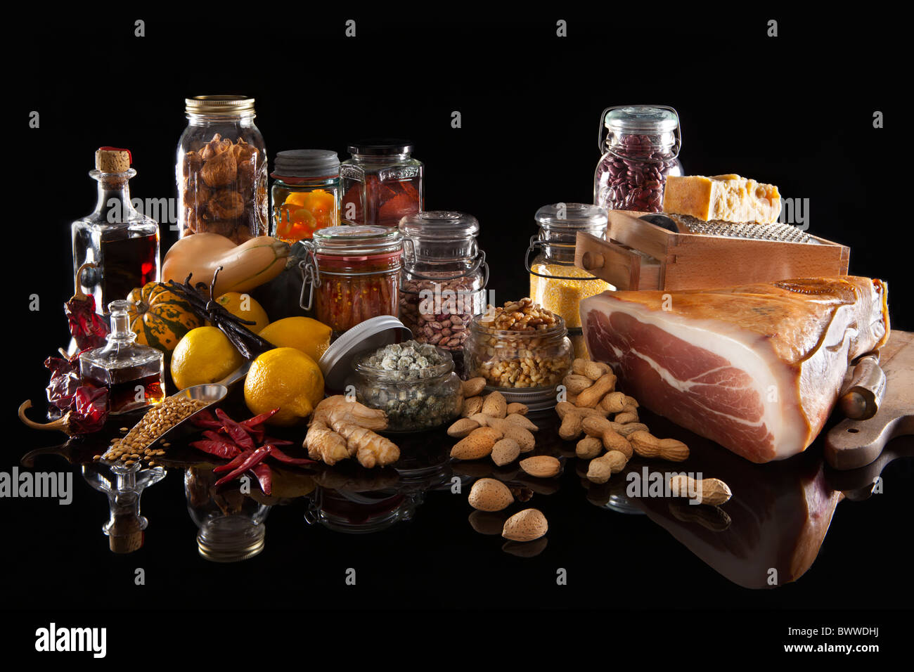 A variety of pantry food in various glass jars and bottles on black background Stock Photo