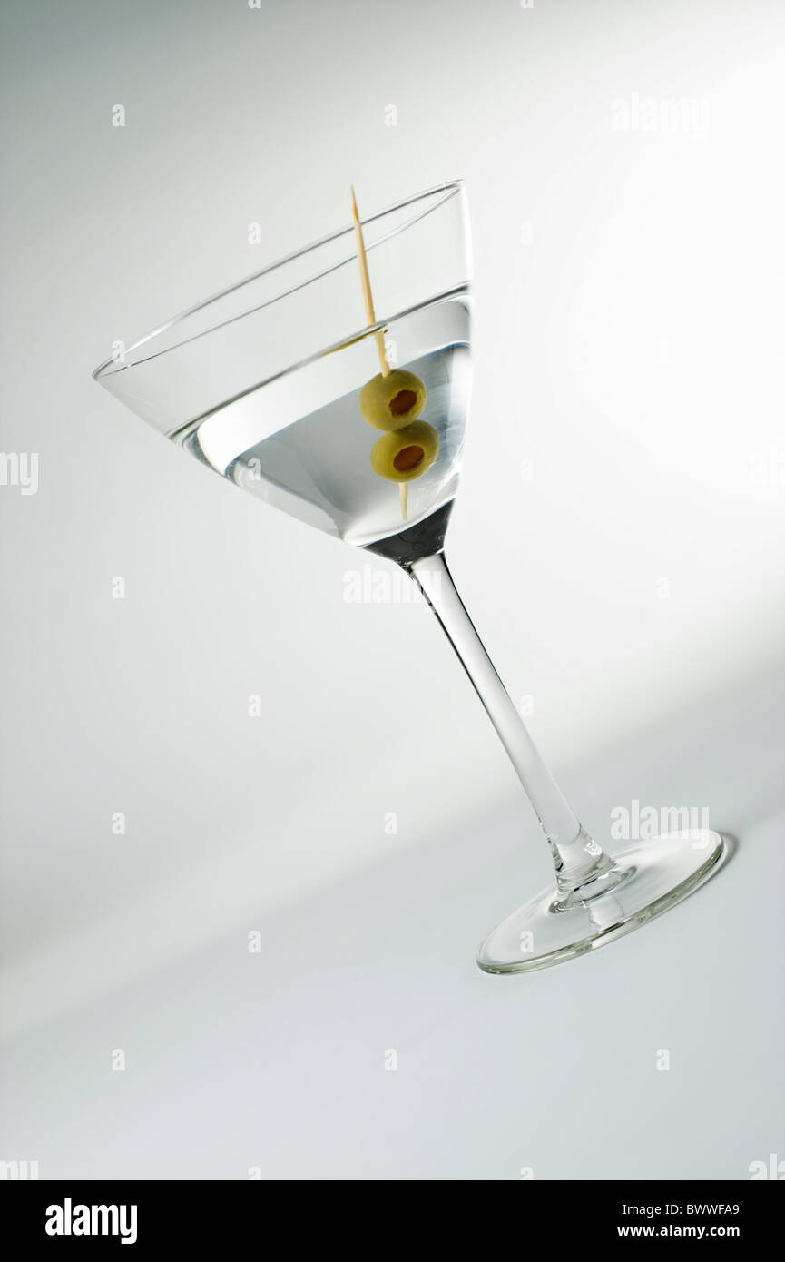 Angled Martini glass with olives on white background Stock Photo
