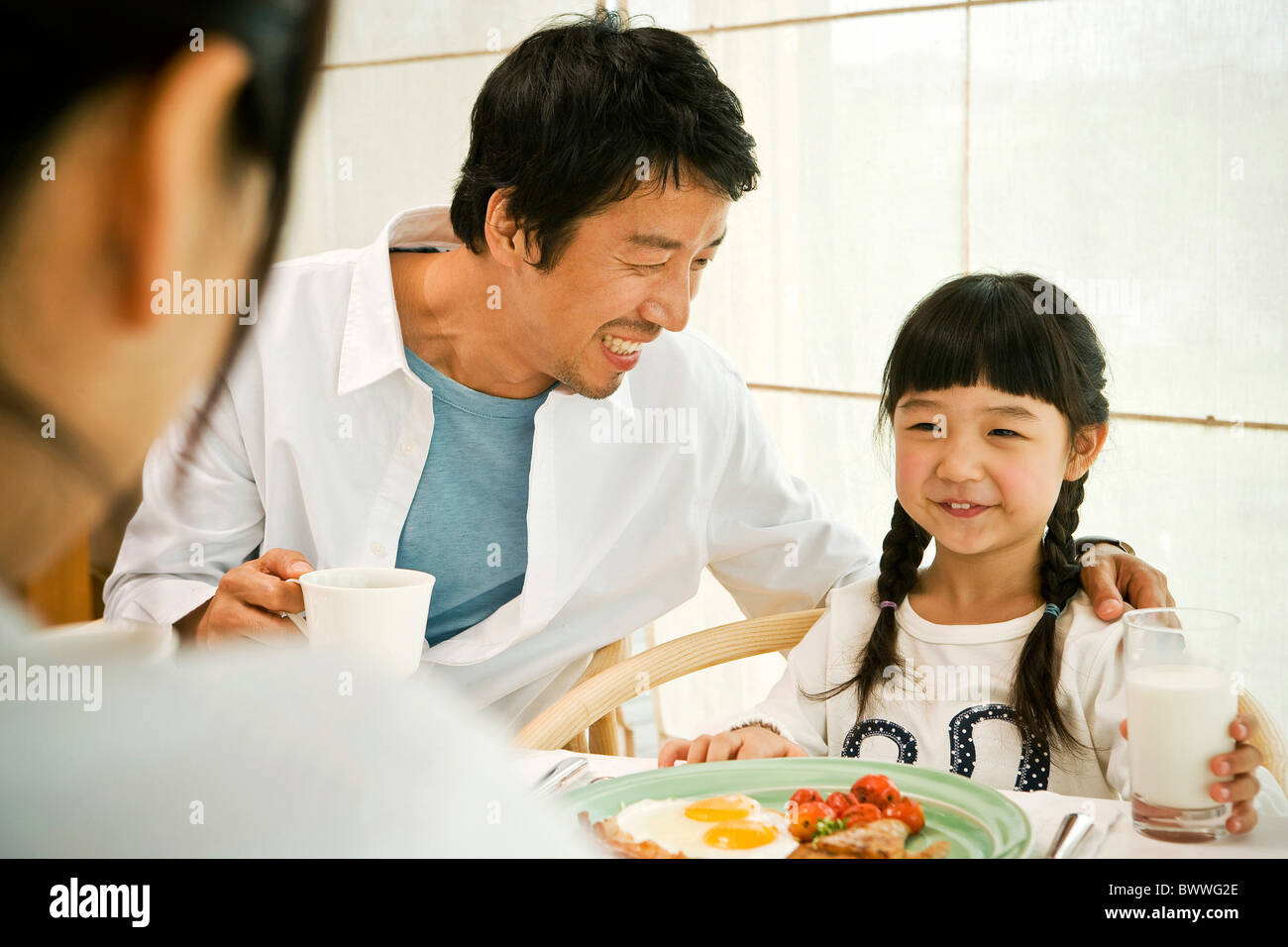 Family having breakfast at table Stock Photo - Alamy