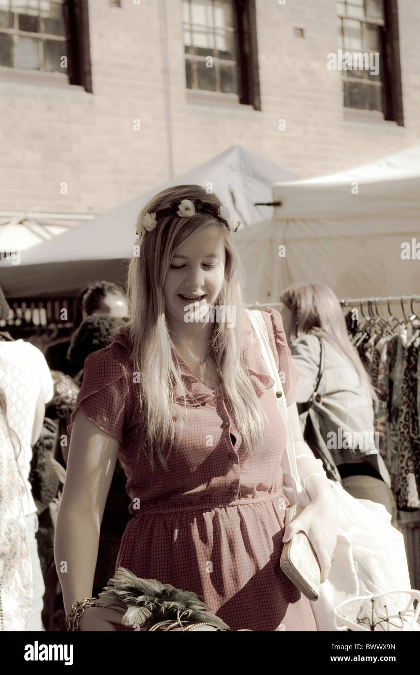 Girl looks through selection of secondhand and vintage clothing for