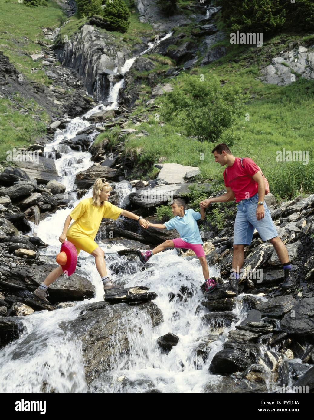Creek brook family hands hold young child middle walking hiking wild ...