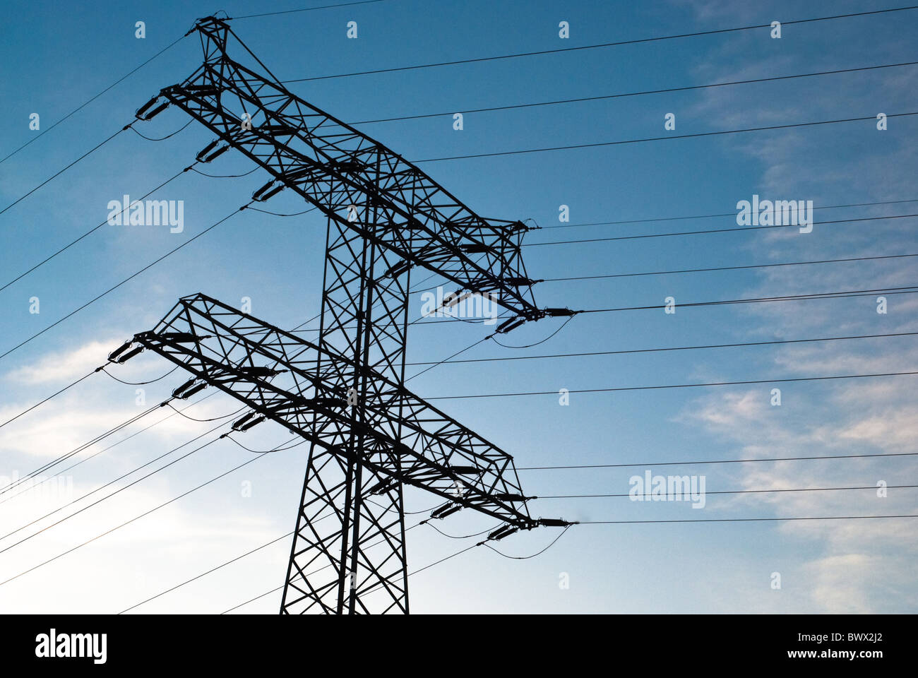 large electricity pylon against blue sky with clouds Stock Photo - Alamy