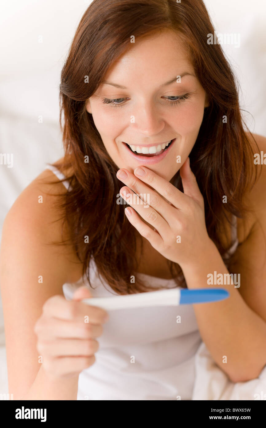 Pregnancy test - happy surprised woman, positive result Stock Photo