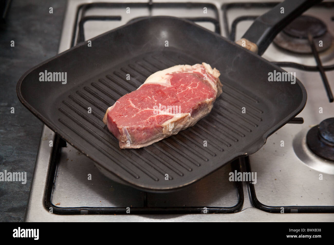 Rump steak being cooked in a griddle pan. Stock Photo