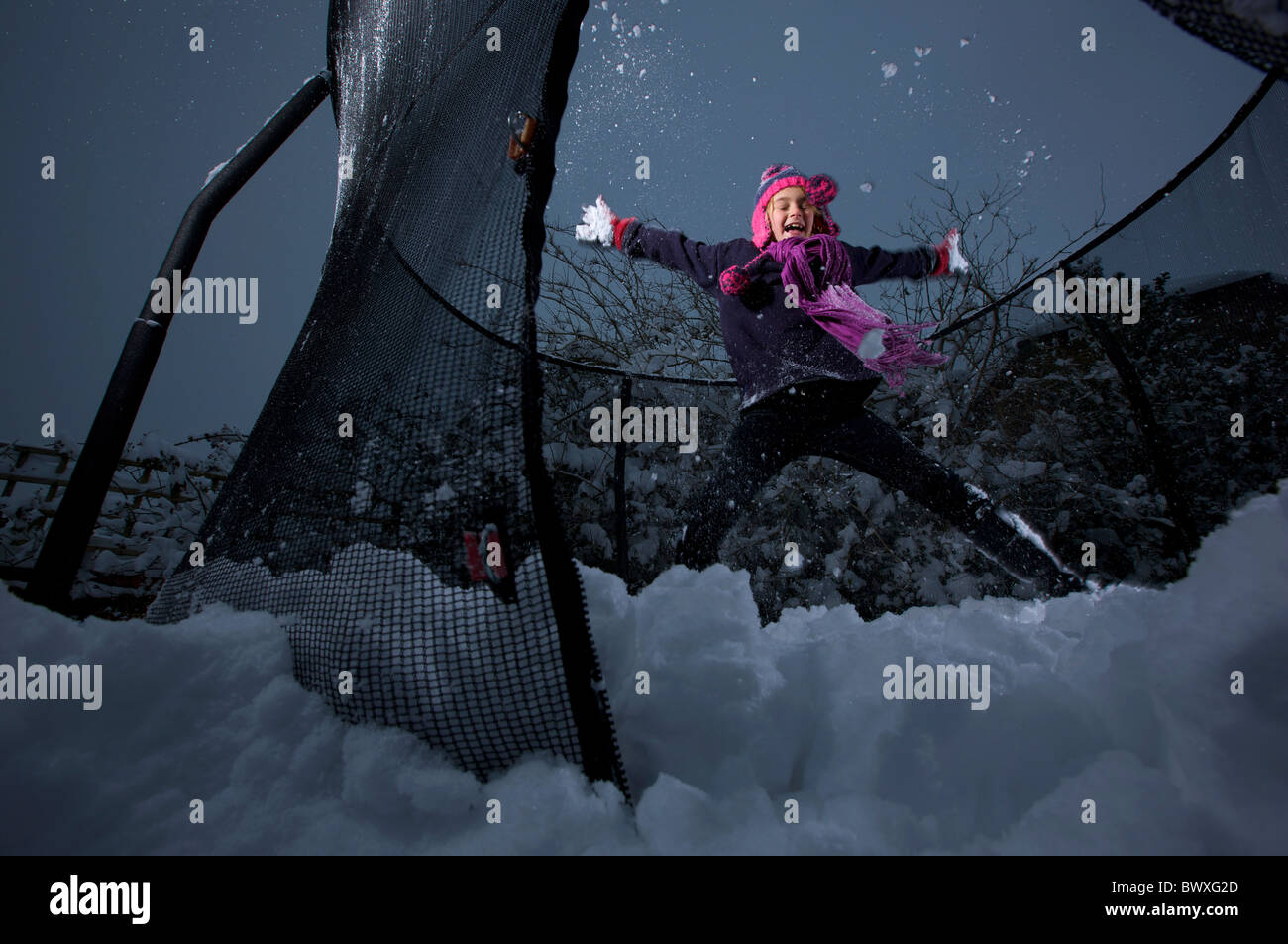 Young girl playing on her garden trampoline in the snow Stock Photo Alamy