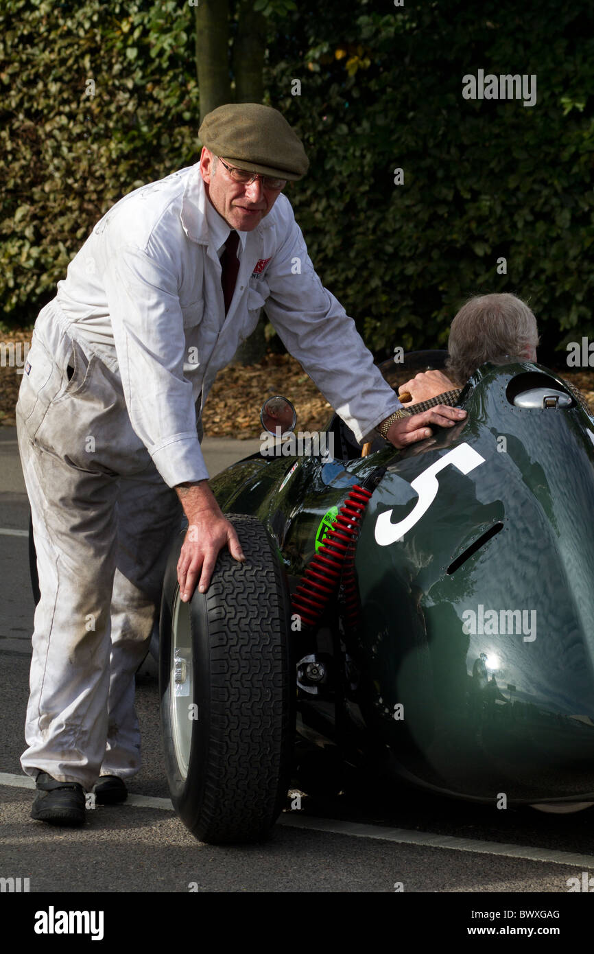 Mechanic pushes the 1958 BRM Type 25 of Gary Pearson into position in the paddock. 2010 Goodwood Revival, Sussex, England, UK. Stock Photo