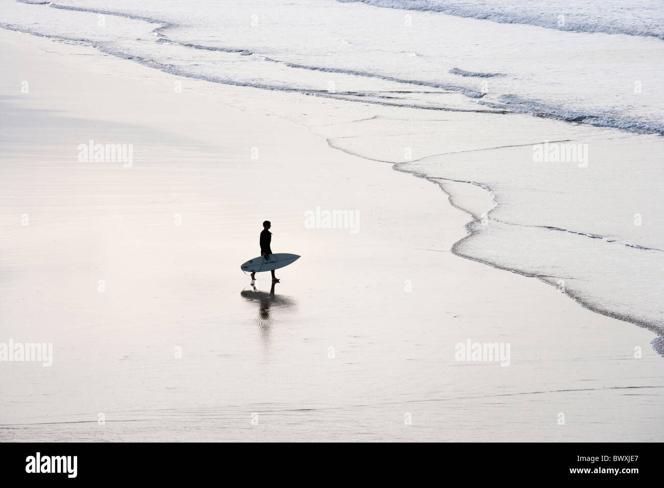 Surfer on beach, Godrevy, Cornwall, UK Stock Photo