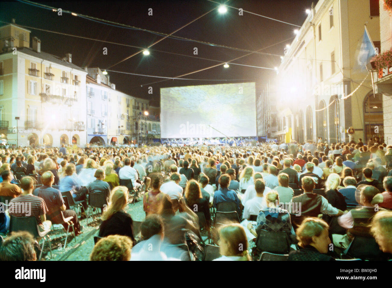 film festival canvas screen Lucerne at night Piazza Switzerland Europe Ticino spectator Stock Photo