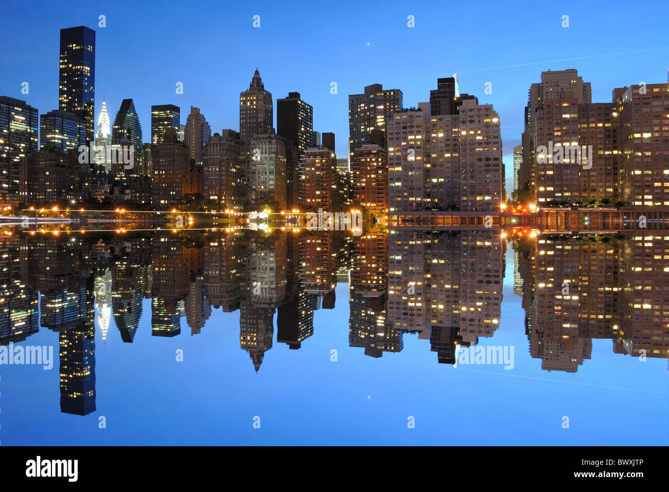 New York City landmark skyline at night with river reflections Stock ...