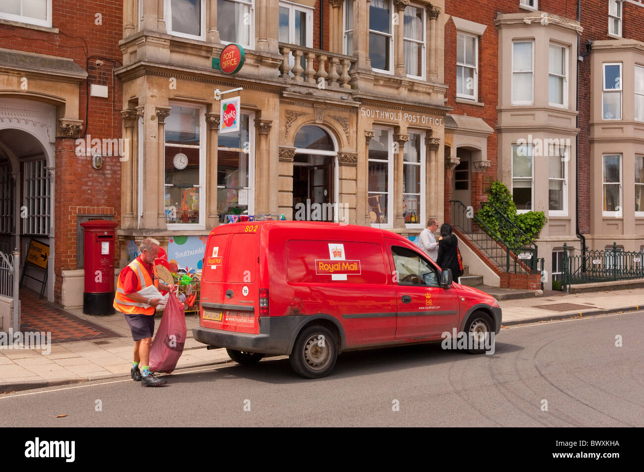 The Post Office shop store with a postman and Royal Mail van outside in Southwold , Suffolk