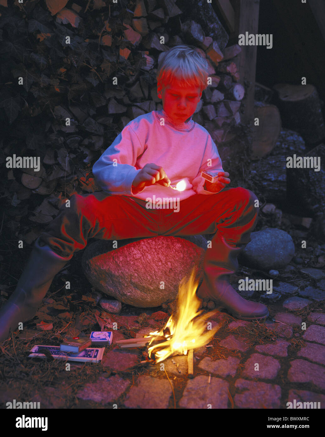 flare pyrotechnic matches burn fires boy child sit small Gefahrr fire pyromaniac at night red light sh Stock Photo
