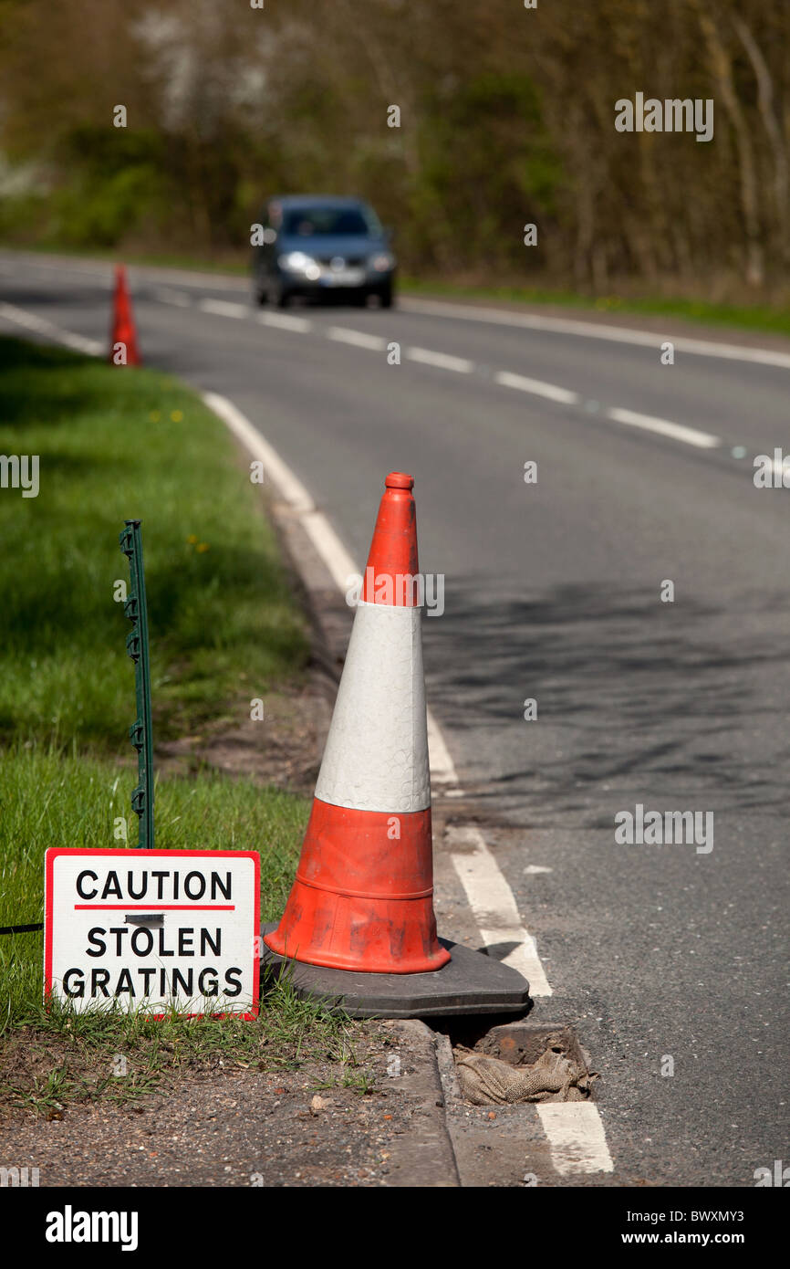 Signage on the A4455 Fosse Way near Princethorpe, Warwickshire, alerting road users to the danger of stolen gratings Stock Photo
