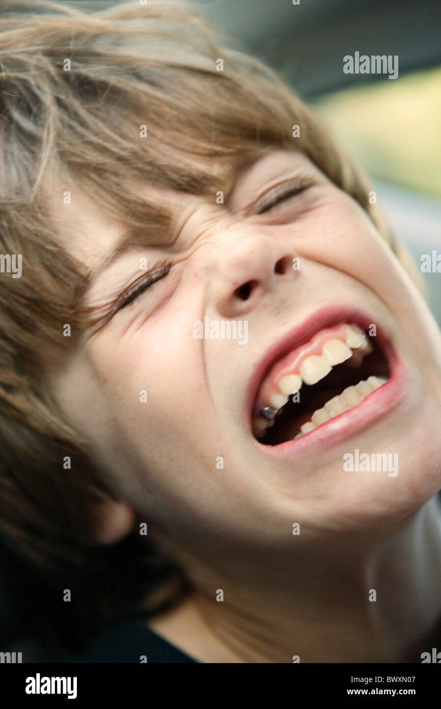 Eight year old boy crying out in agony, close up of face. Stock Photo