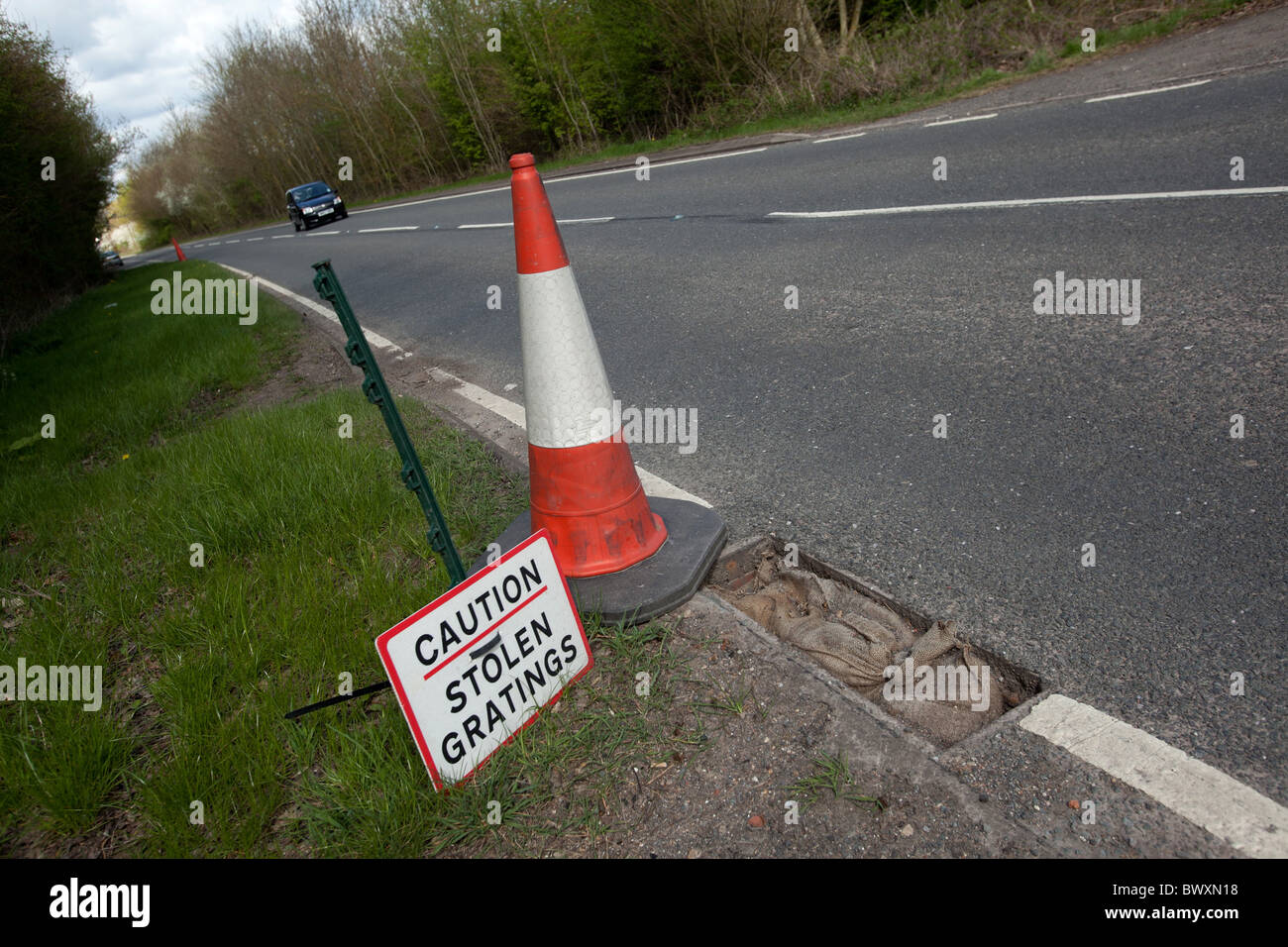 Signage on the A4455 Fosse Way near Princethorpe, Warwickshire, alerting road users to the danger of stolen gratings Stock Photo