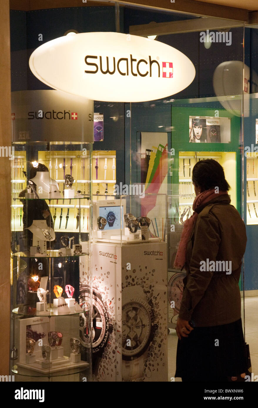 A woman looking in a Swatch shop window, Paris, France Stock Photo