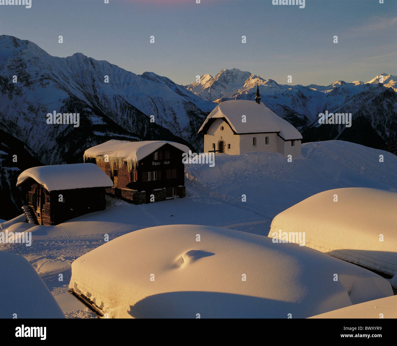 evening light Bettmeralp houses homes church scenery Switzerland Europe Valais winter Stock Photo