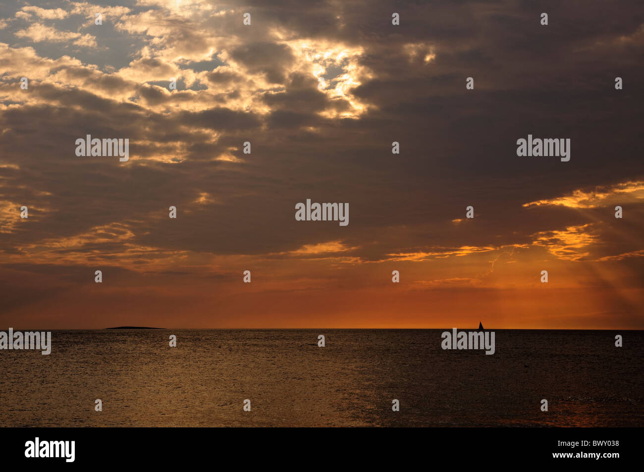 Seascape in sunset with sailboat silhouette Stock Photo