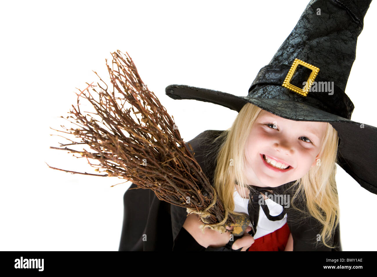 Portrait of girl in halloween costume and broom smilling at camera