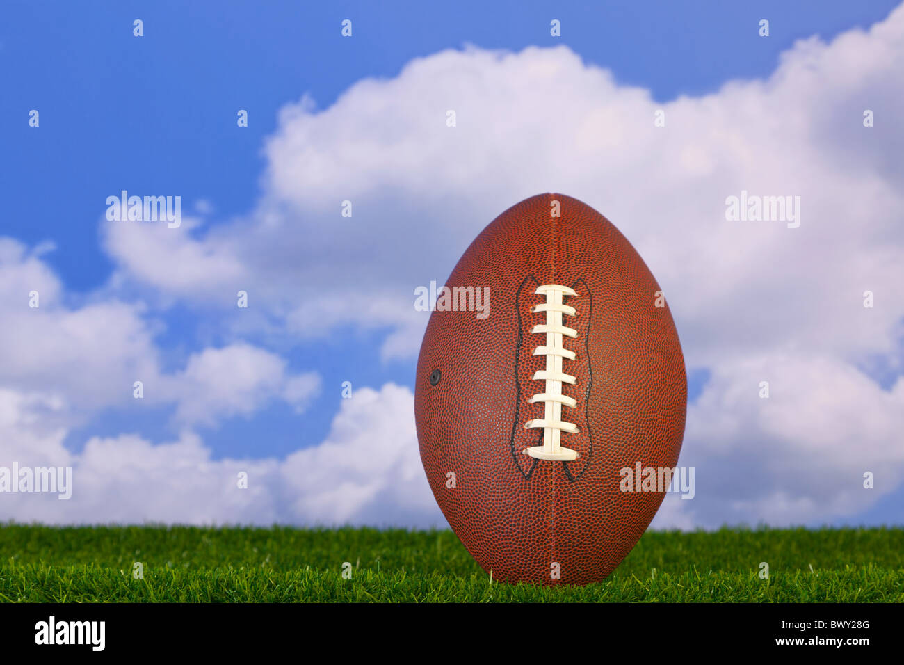 Photo of an American football tee'd up on the grass Stock Photo