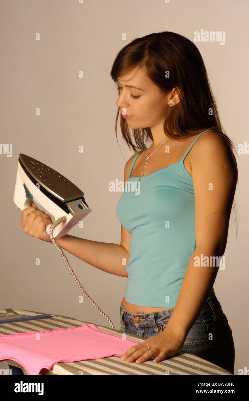 brown hair girls flat iron household ironing ironing board Jeans jewellery jewelry long hair studio teena Stock Photo