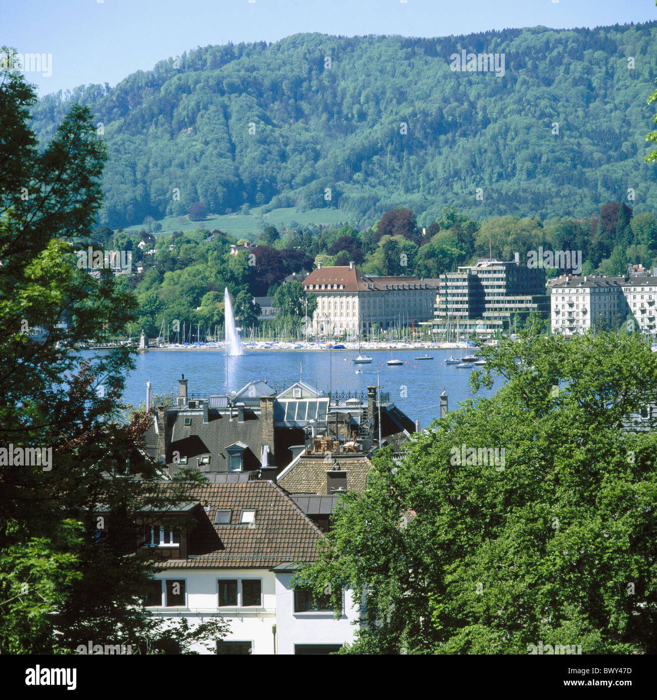 roofs jet fountain building construction Mythenquai lake sea Seefeld mountain utli town city Zurich Swi Stock Photo