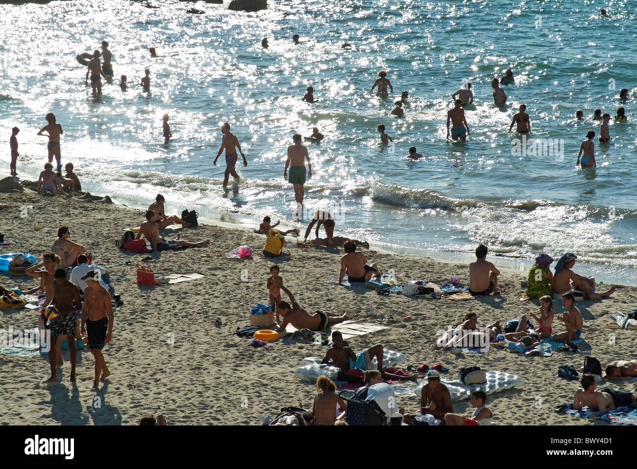 People swimming and sunbathing at Prophete Beach at Marseille, South of France in high summer Stock Photo