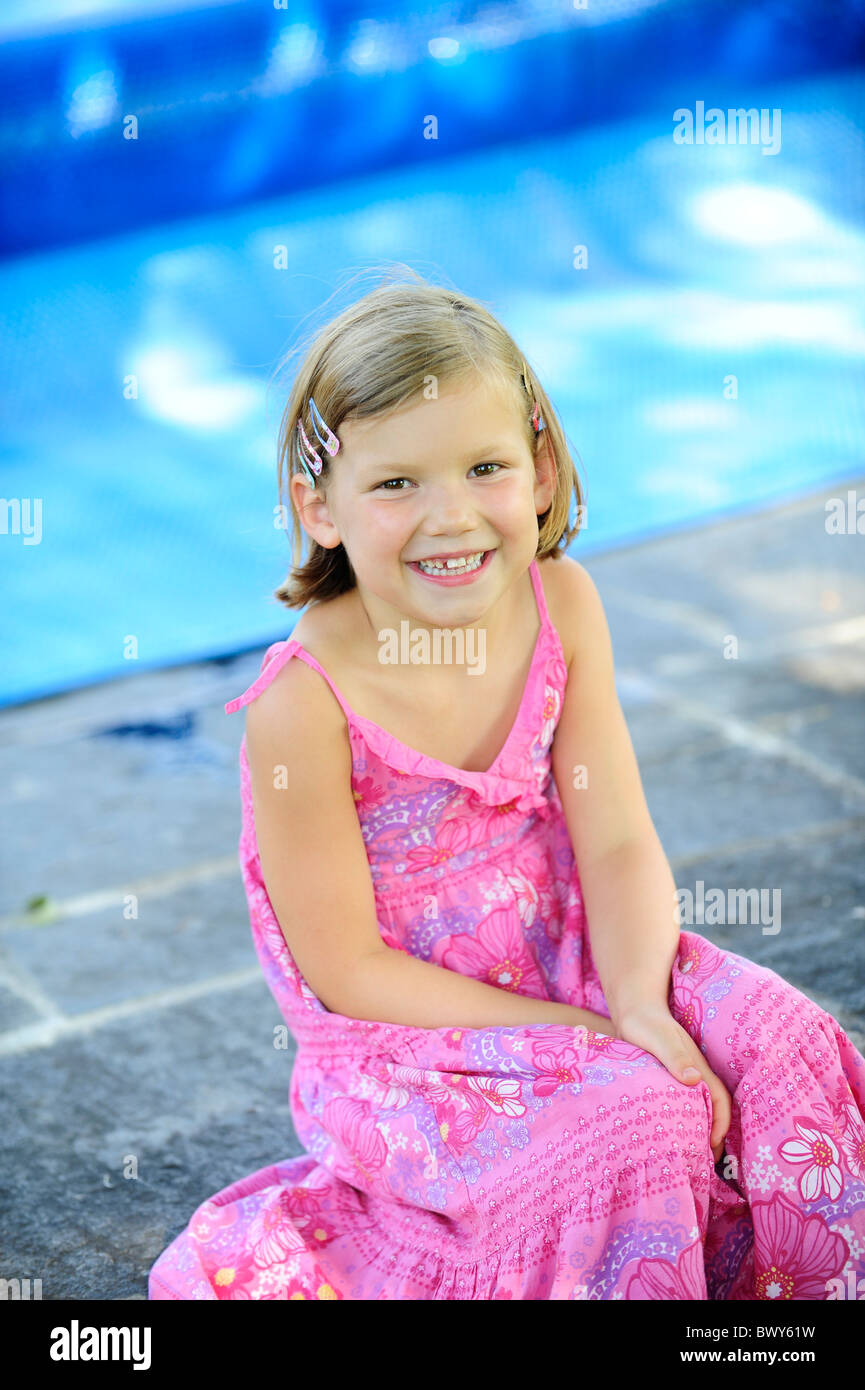 A young girl with a pink dress relaxing in a garden Stock Photo