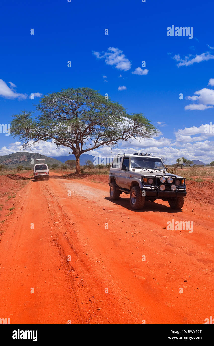Safari Vehicles on Dirt Road, Tsavo National Park, Kenya Stock Photo