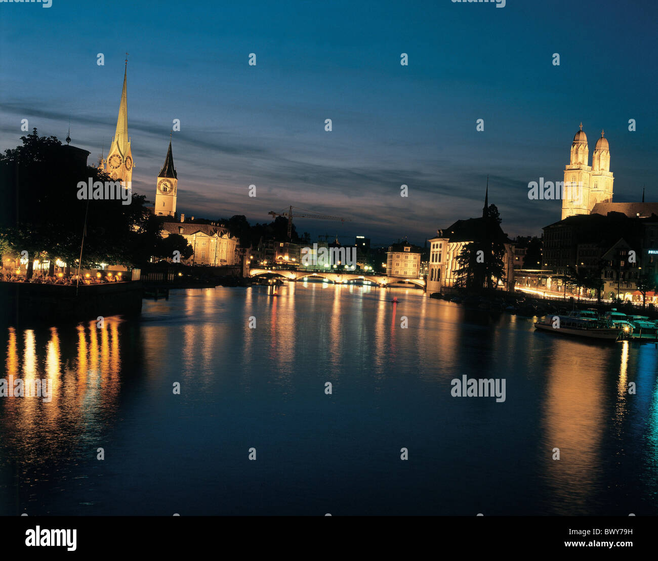 at night Bauschanzli boats churches city Fraumunster Grossmunster minster church cathedral Limmat Munster Stock Photo