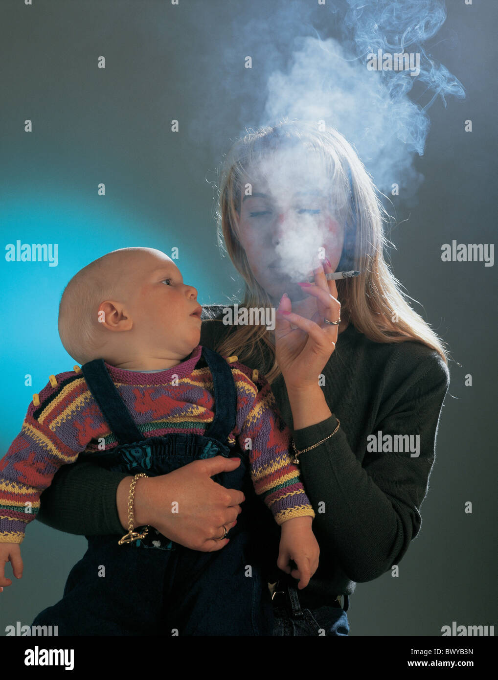 baby bad model child dangerous dense smoke health injurious mother negative problem problematical responsi Stock Photo