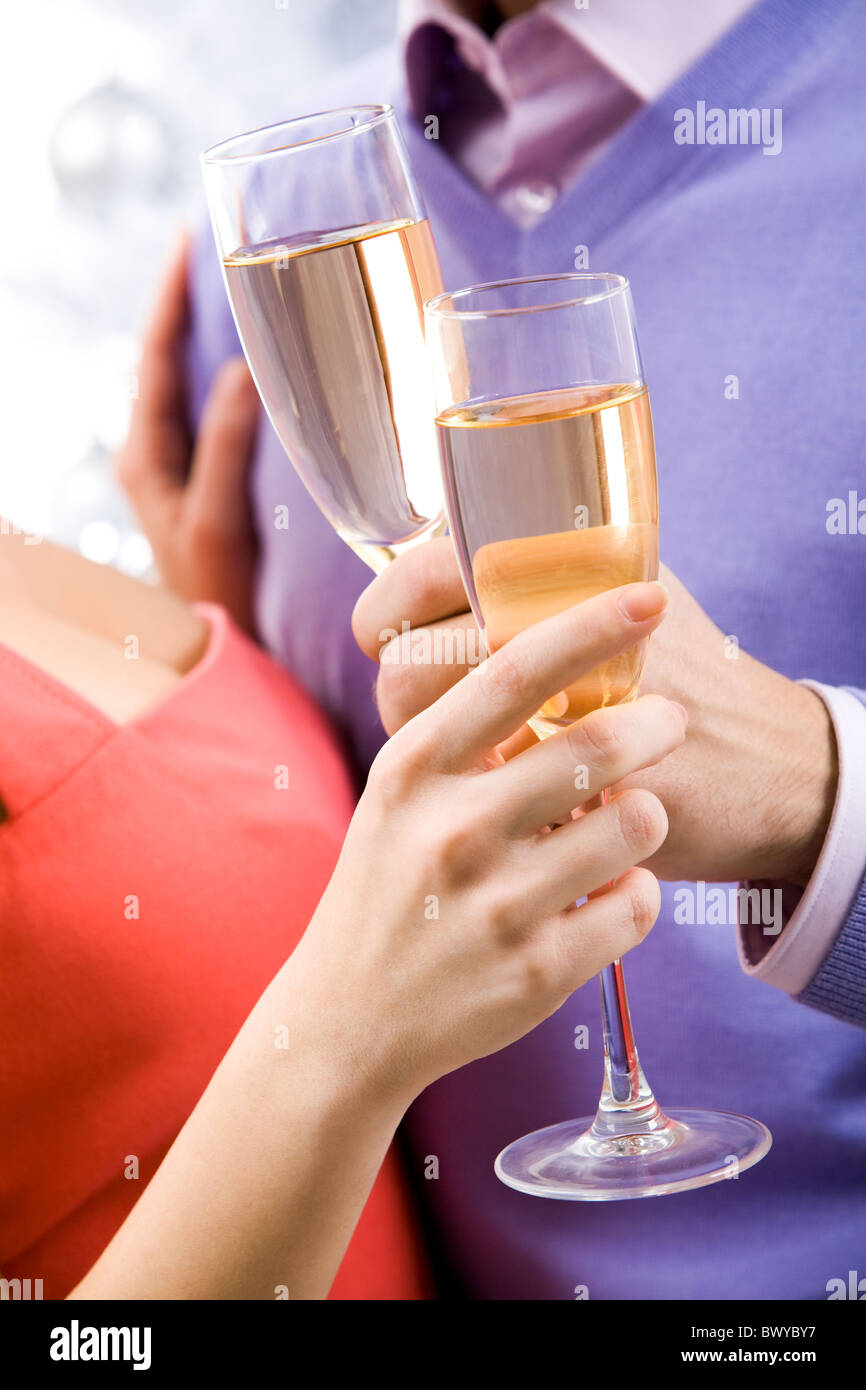 Close-up of couple hands holding champagne flutes during celebration ...