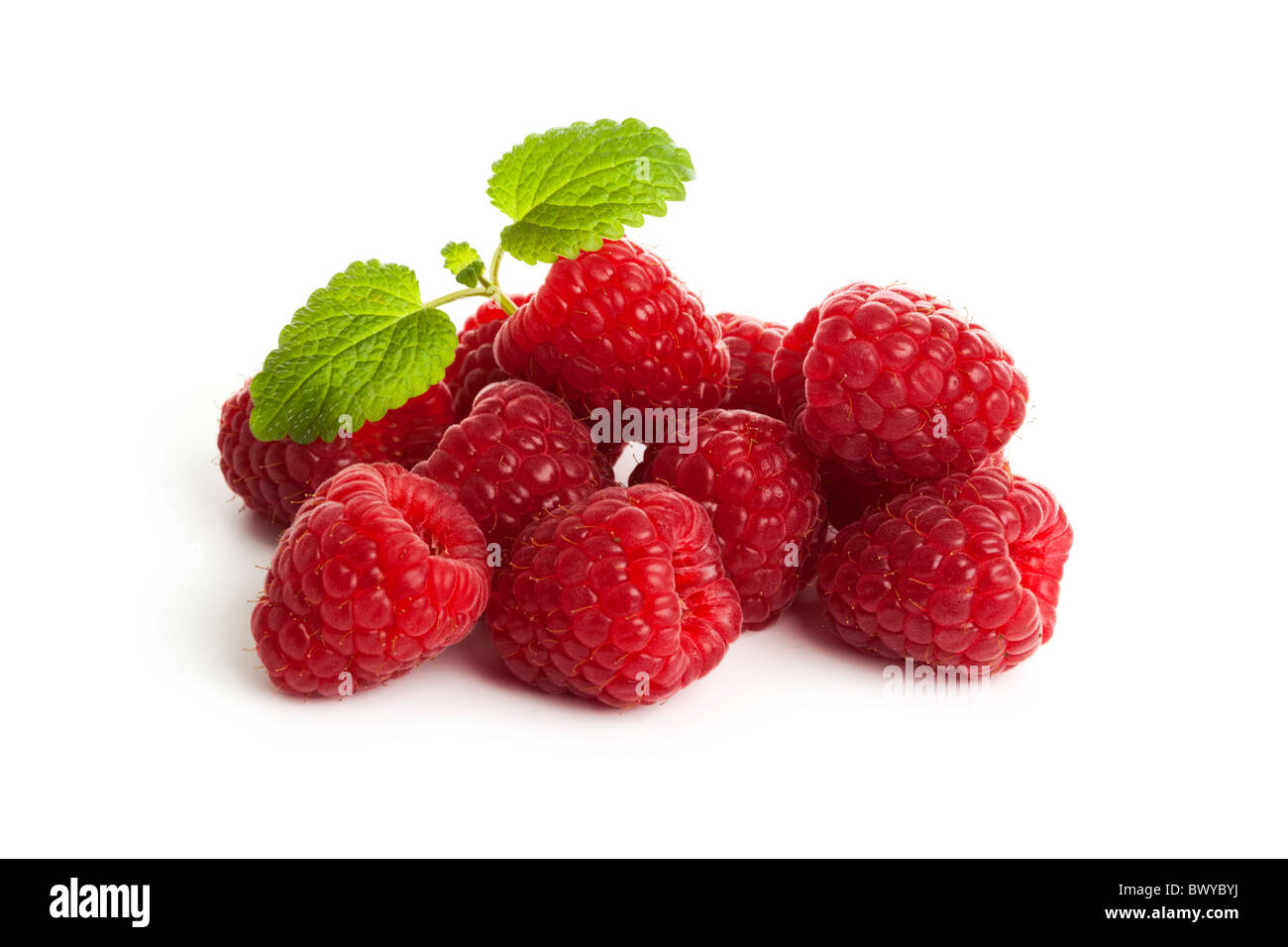 heap of fresh raspberries garnished with mint leaves on white background Stock Photo