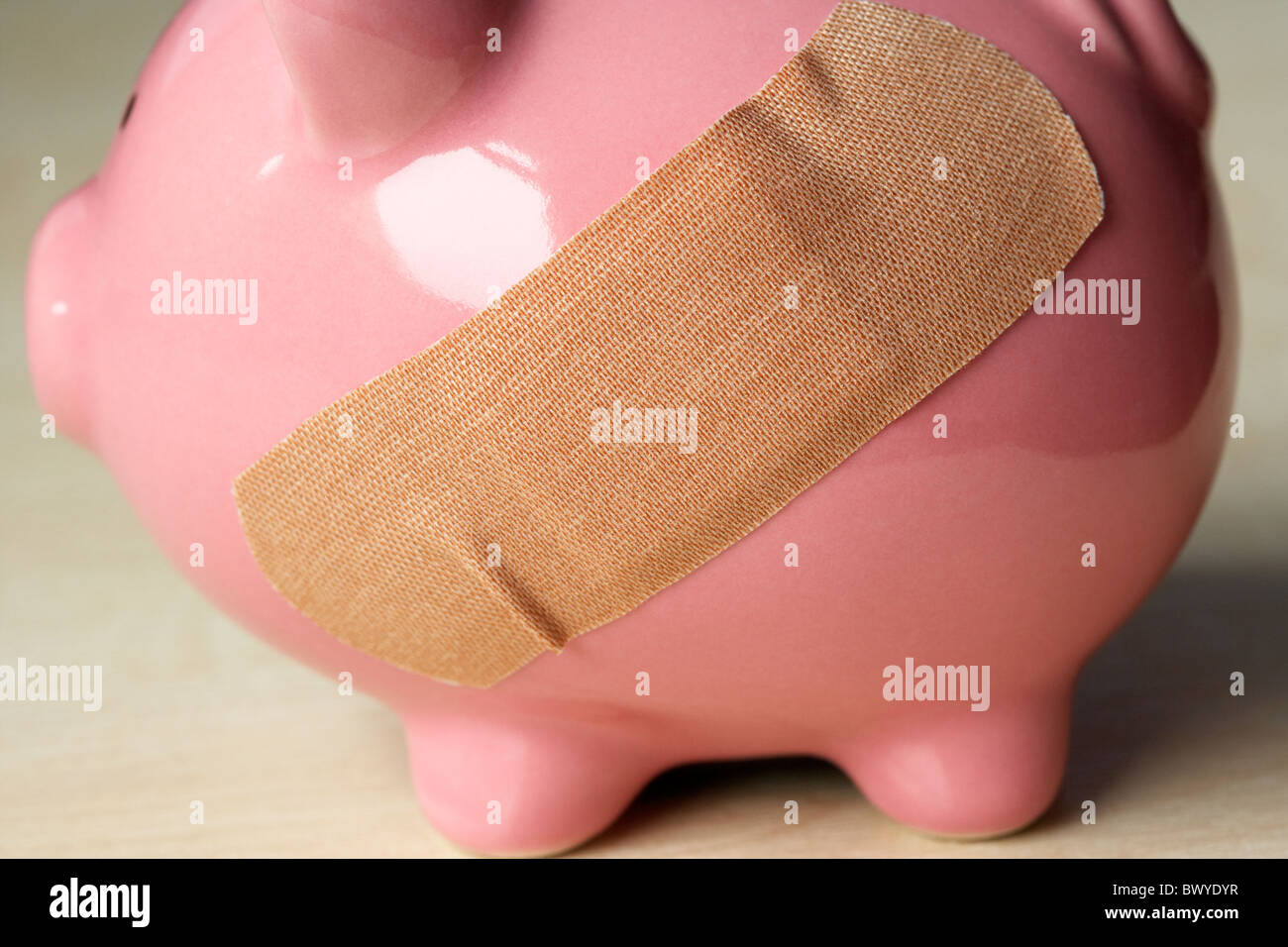 sticking plaster on pink piggy bank Stock Photo