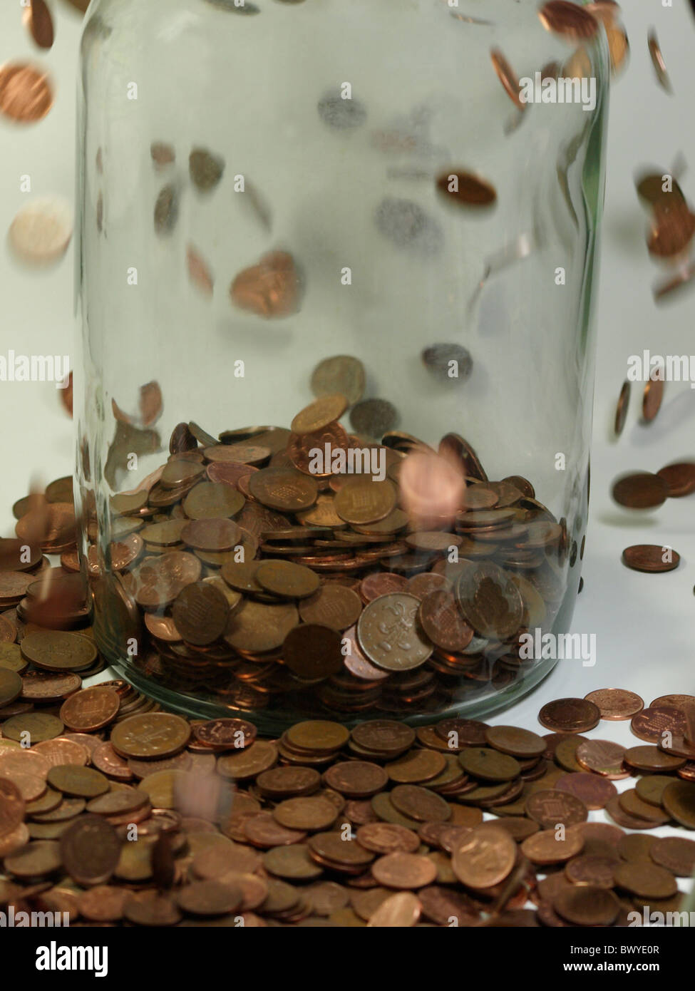 Putting pennies into a jar, UK Stock Photo