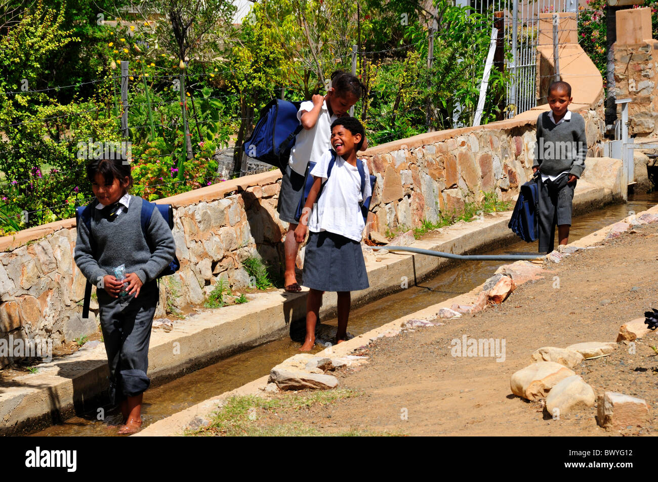 School children play in the water duct. Prince Albert, South Africa. Stock Photo