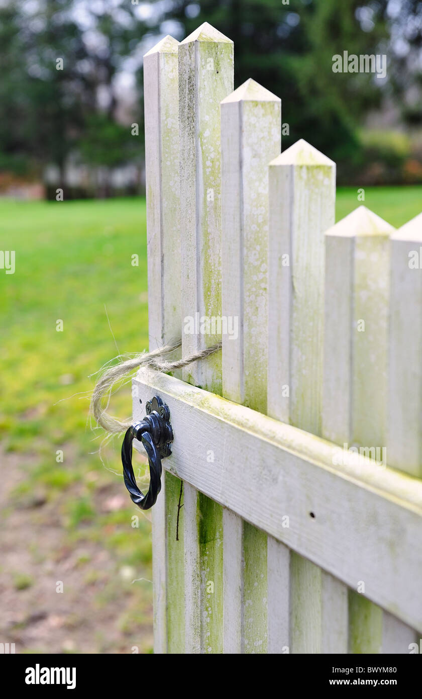 Old weathered open gate inviting you into the garden with selective focus shallow depth of field soft focus Stock Photo