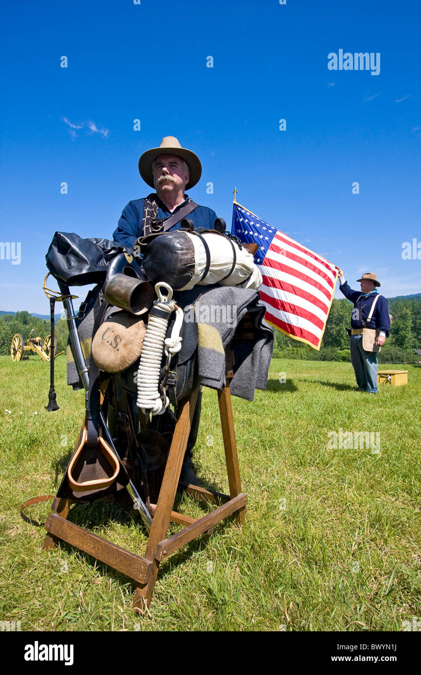 Man portrays sergeant from the 1880s, leaning on his horse saddle with