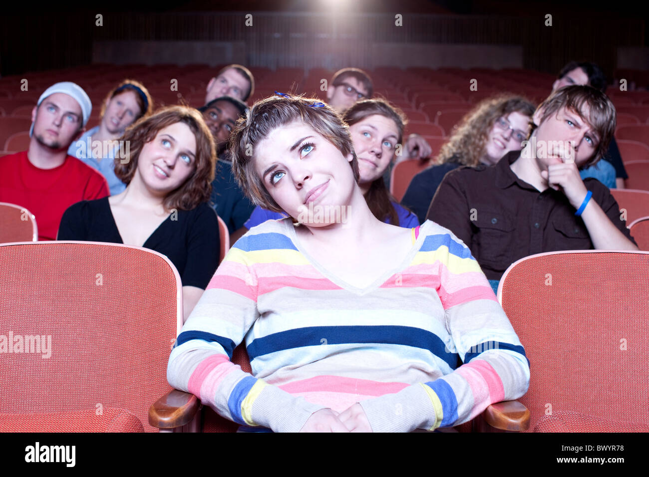 Caucasian woman watching movie in theater Stock Photo