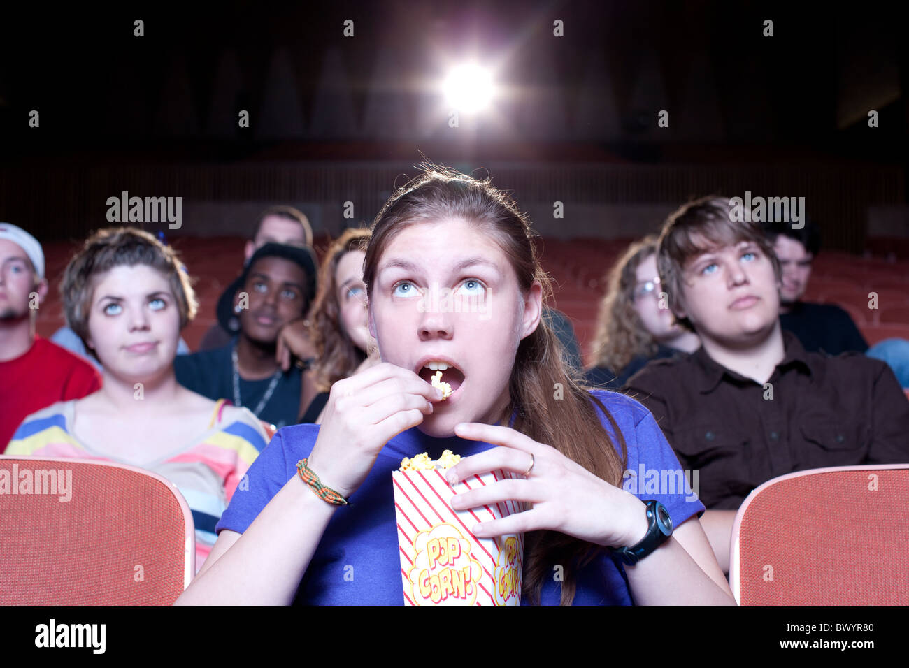 Caucasian woman eating popcorn in movie theater Stock Photo