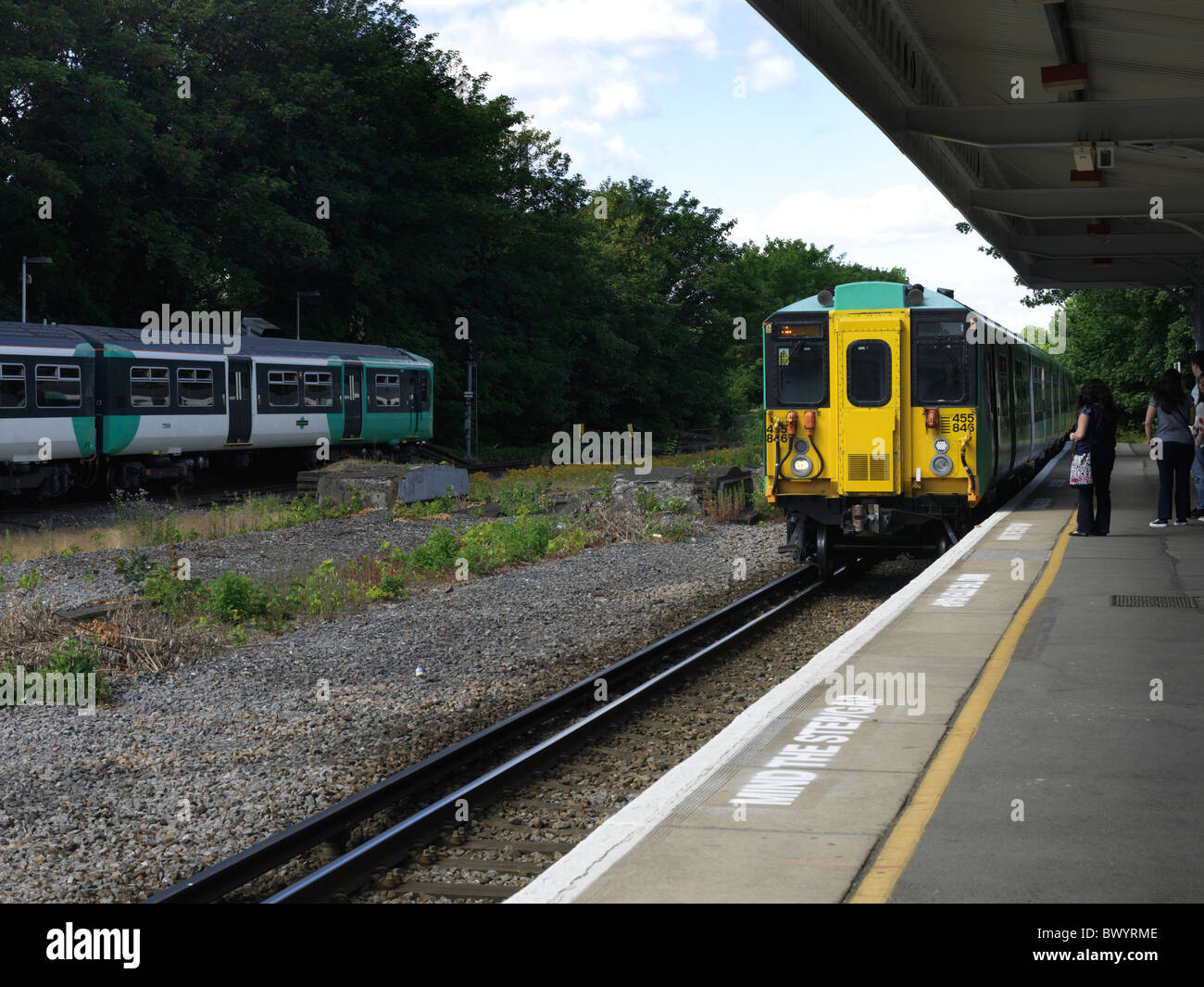 Cheam Surrey England Train Arriving and A Train Leaving cheam station People Waiting On Platform Stock Photo