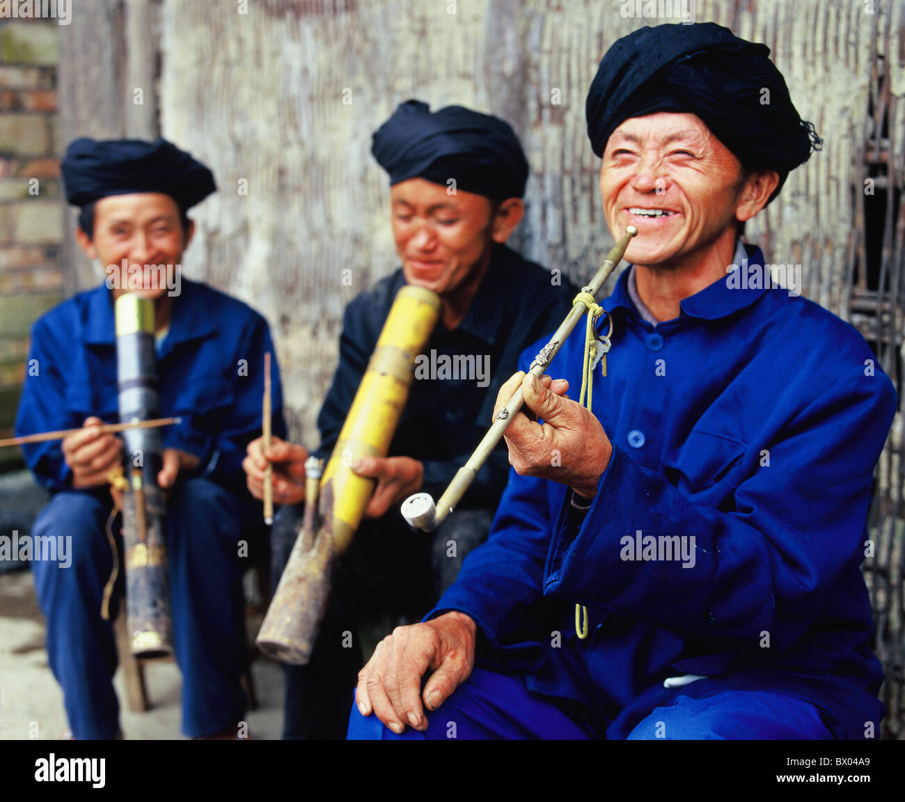White Miao man in traditional costume smoking tobacco pipe, Xinzhai,  Shechang, Longlin, Baise, Guangxi Province, China Stock Photo