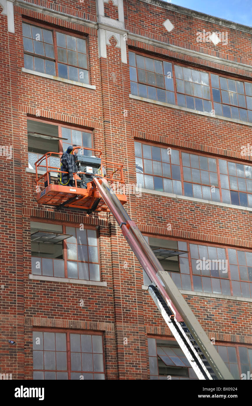 Man on hydraulic lift washing windows Stock Photo - Alamy